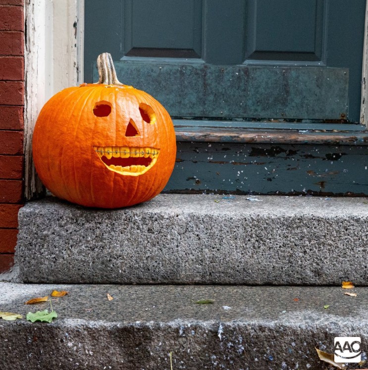 Pumpkin on patio steps wearing braces.