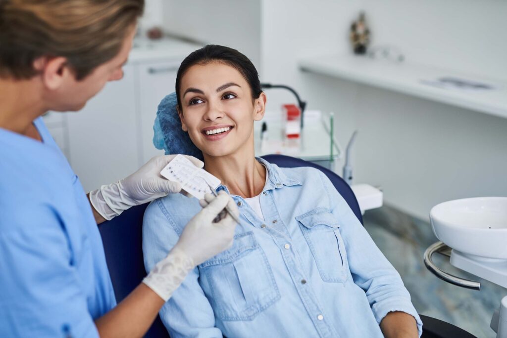 A woman listening to how traditional braces work, using brackets, wires, and sometimes elastic bands to straighten teeth.