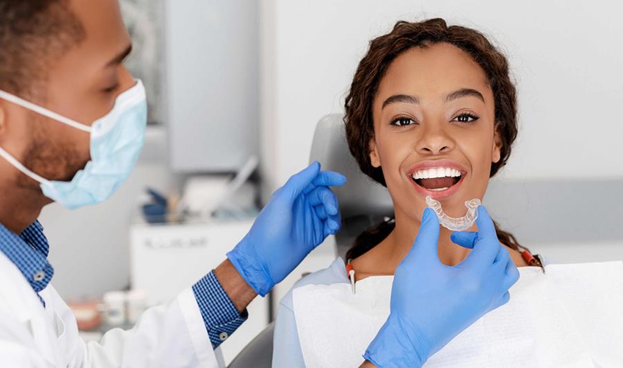 Young woman getting safe and effective aligners at the orthodontic office versus the risks associated DIY treatment.