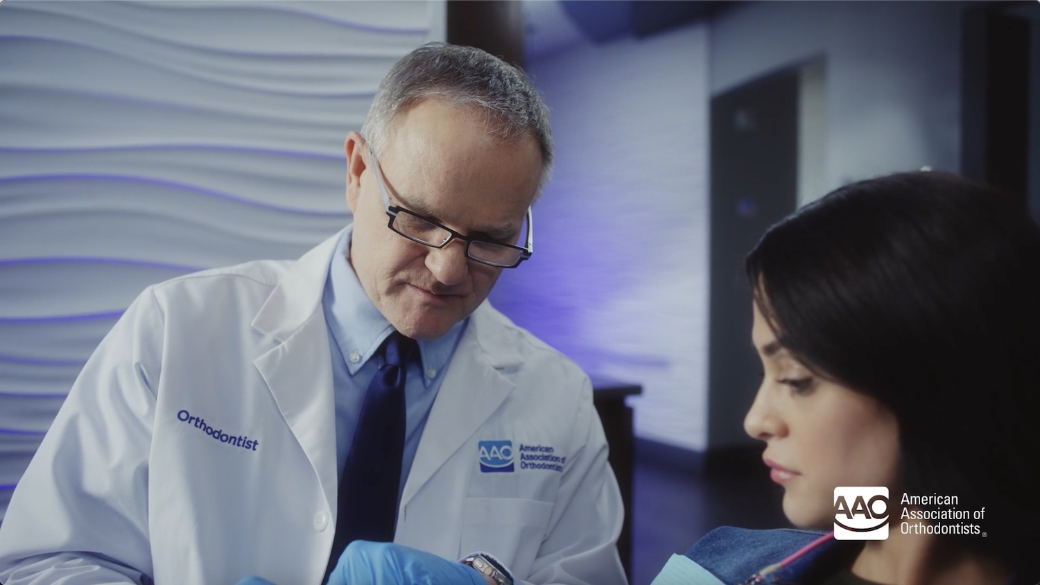 An orthodontist conducting an in-person consultation, thoroughly examining a patient's teeth, jaws, bite, and facial structure to identify orthodontic issues.