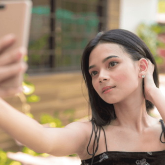 A teenage girl taking a selfie, representing Mewing, a DIY facial restructuring trend, with a reminder that tongue posture alone cannot replace proper orthodontic treatment. And there is no scientific evidence to support the Mewing claims.
